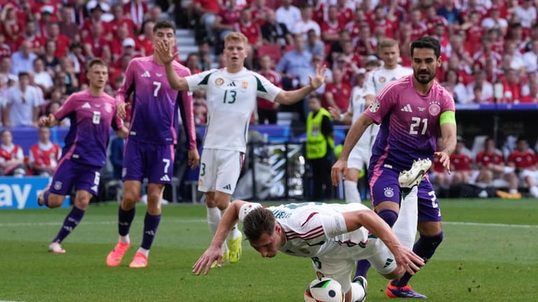 Hungary's Willi Orban falls on the ball while defending near...