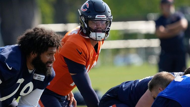 Chicago Bears quarterback Caleb Williams, center, works with teammates during...