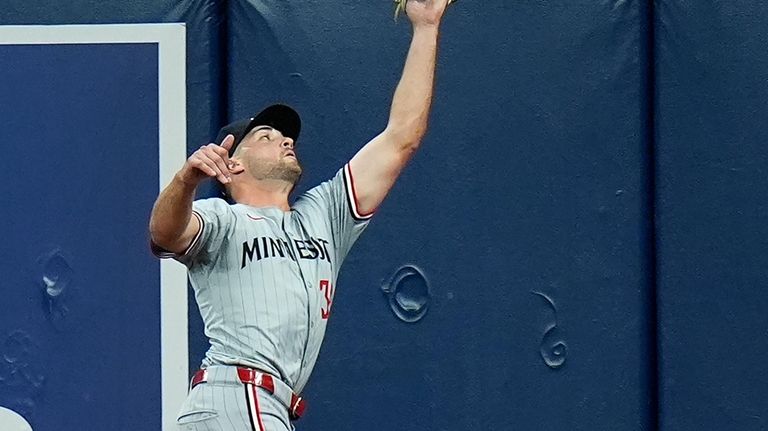 Minnesota Twins right fielder Matt Wallner makes a leaping catch...