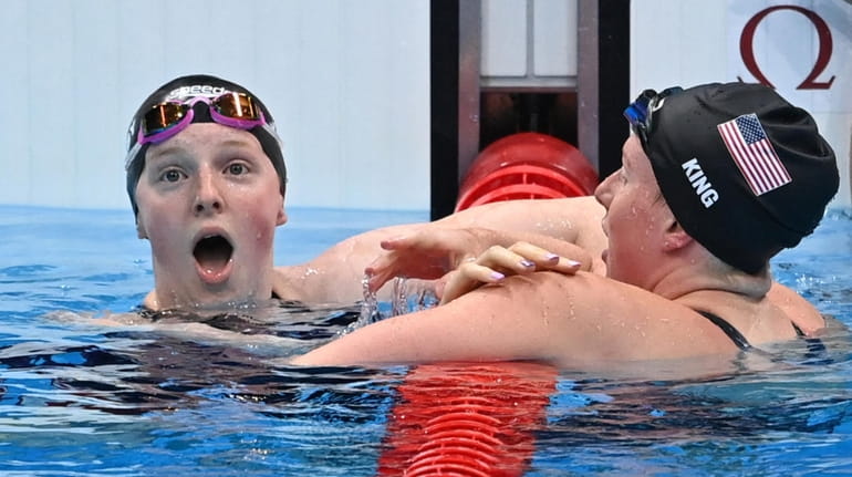 USA's Lydia Jacoby (L) celebrates winning with third-placed USA's Lilly...
