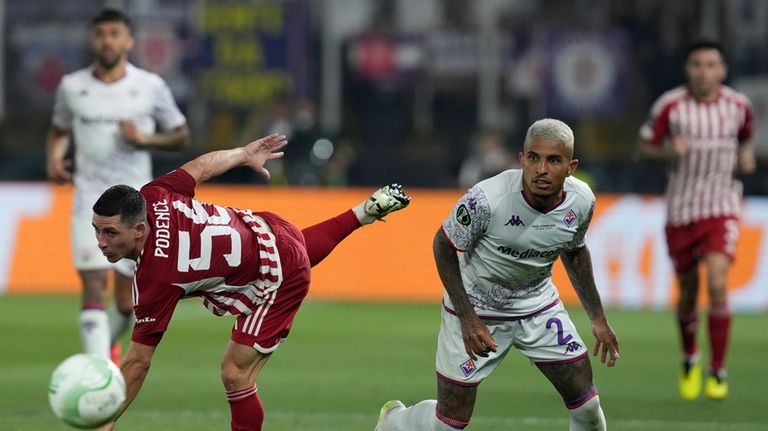 Olympiacos' Daniel Podence, left, goes for the ball with Fiorentina's...