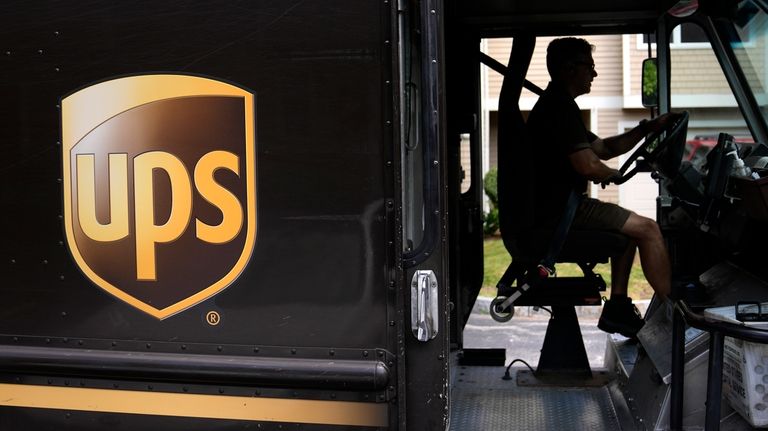 A United Parcel Service driver steers through a neighborhood while...