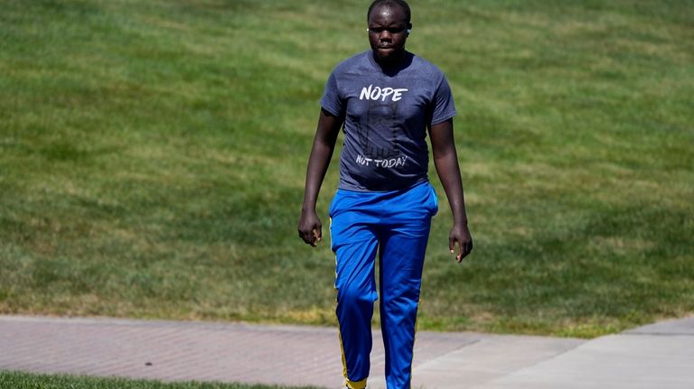 Ronald Okee, of Des Moines, Iowa, walks barefoot along the...