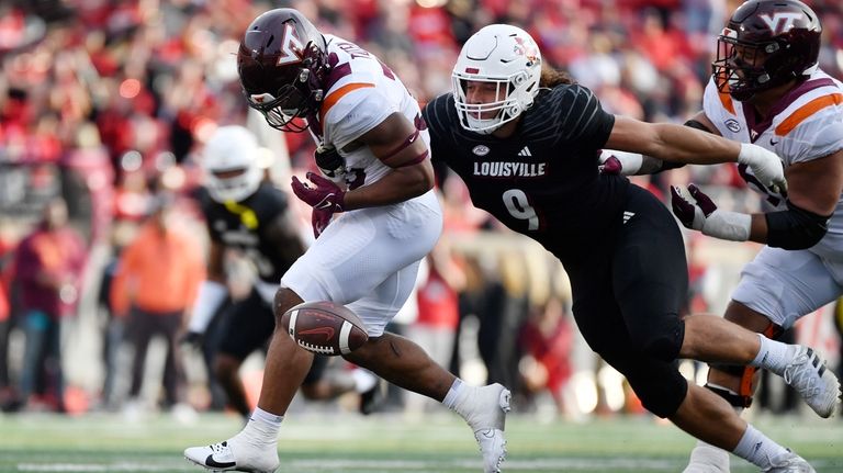 Louisville defensive lineman Ashton Gillotte (9) punches the ball away...