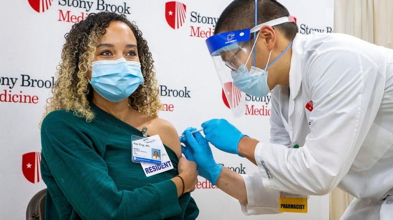 Department of Emergency Medicine resident Dr. Kisa King gets the first dose...