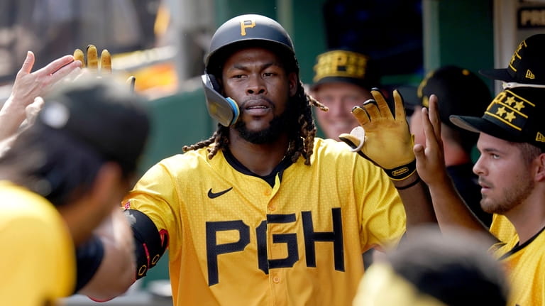 Pittsburgh Pirates' Oneil Cruz celebrates in the dugout after hitting...