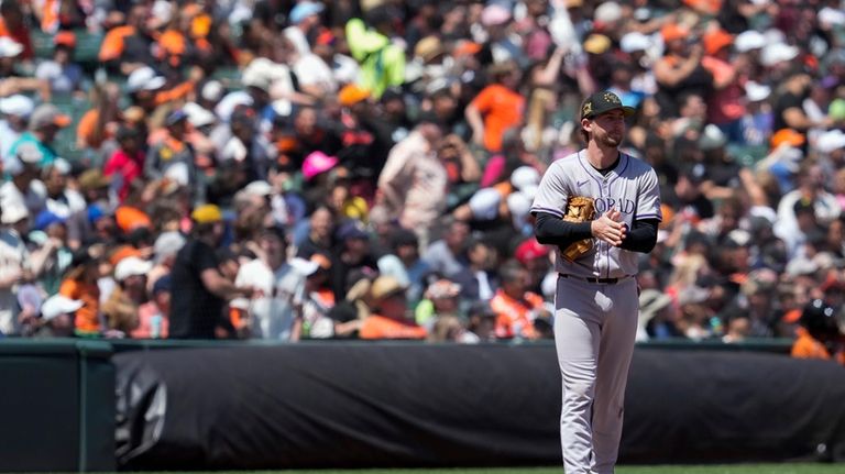 Colorado Rockies third baseman Ryan McMahon reacts after committing a...