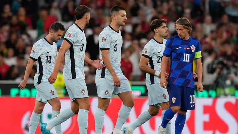 Portugal's Diogo Dalot, center, walks toward Croatia's Luka Modric after...