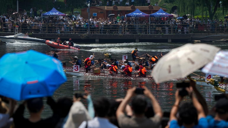 Residents watch a dragon boat race during the Dragon Boat...