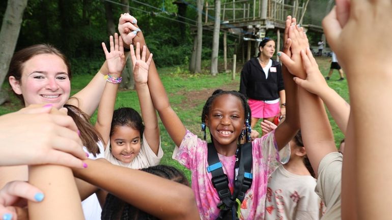 A camp photographer captures Genevive Philogene, 7, of Freeport, celebrating...