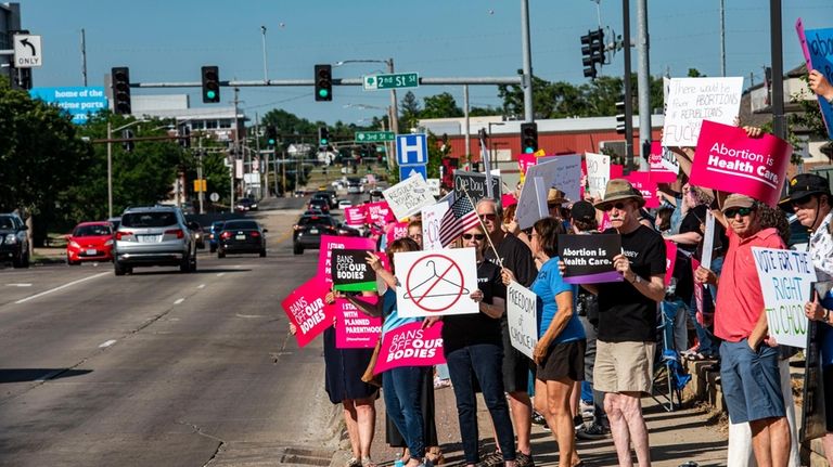 Protestors display sings to passing traffic in Cedar Rapids, Iowa...