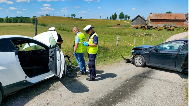 Police officers are investigating the site of a crash between...