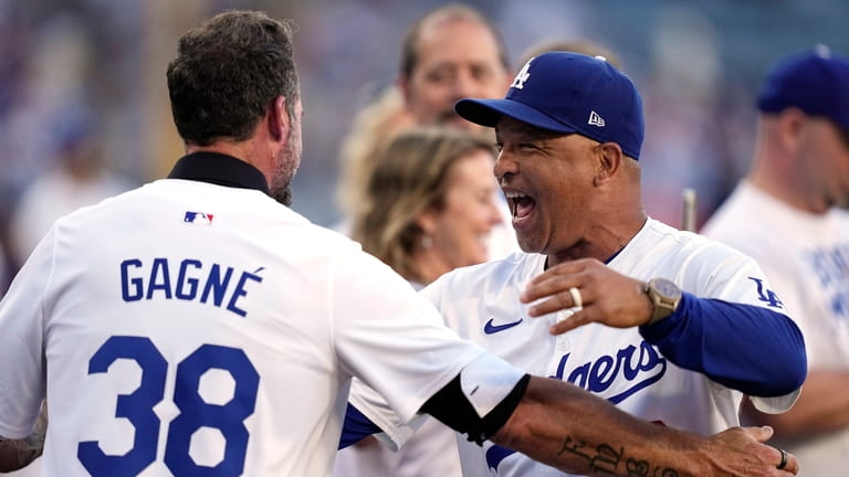 Los Angeles Dodgers manager Dave Roberts, right, greets former Dodger...