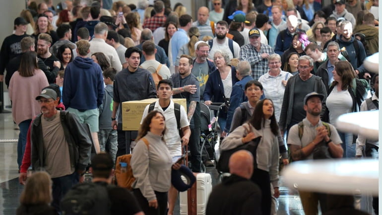 Travelers walk through Salt Lake City International Airport Friday, May...