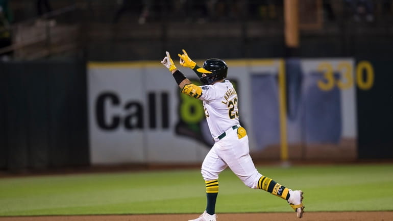 Oakland Athletics' Shea Langeliers gestures as he runs the bases...
