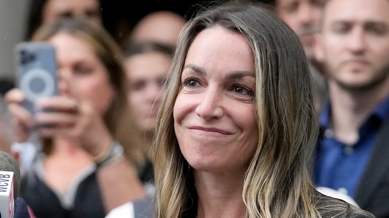 Karen Read smiles during a news conference in front of...