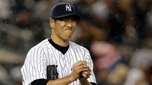 Rain falls as Hiroki Kuroda reacts after allowing a solo...