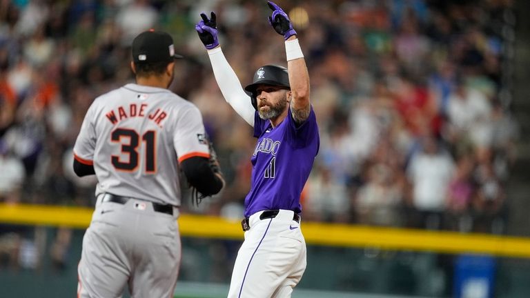 Colorado Rockies pinch-hitter Jake Cave, right, gestures to the dugout...