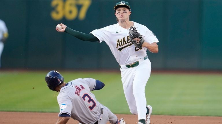 Oakland Athletics second baseman Zack Gelof, right, throws to first...