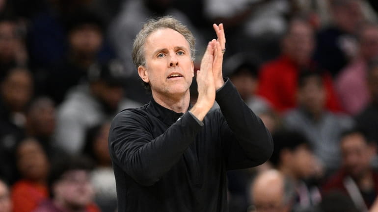 Washington Wizards interim head coach Brian Keefe applauds his players...