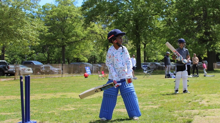 Akash Khargie, 8, left, learns proper bat holding and wicket...