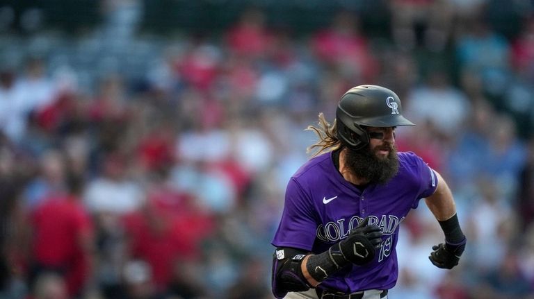 Colorado Rockies designated hitter Charlie Blackmon runs to first base...