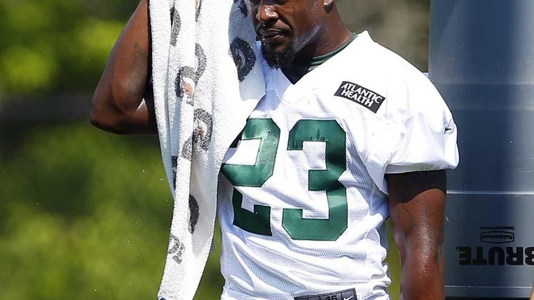 Jets running back Mike Goodson wipes the sweat off his...