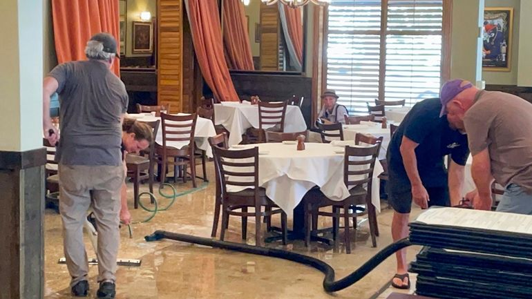 Workers dry the floor of The Steak Knife, aNew Orleans...