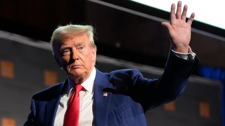 Republican presidential nominee former President Donald Trump waves as he...