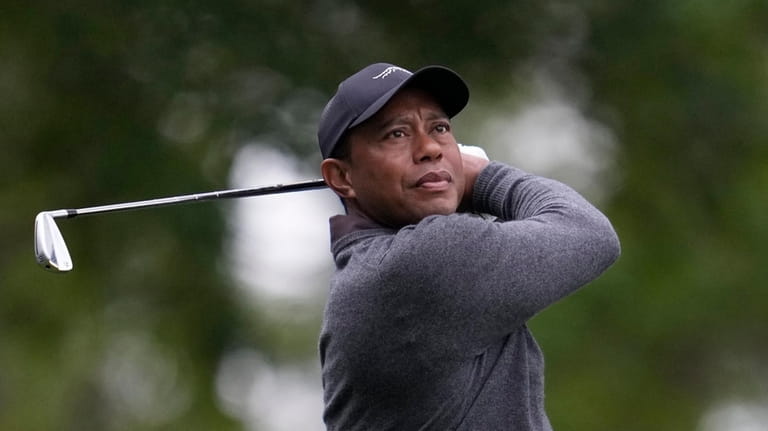 Tiger Woods watches his shot on the fourth hole during...
