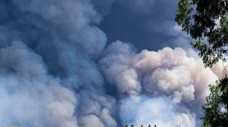 Firefighters monitor the Airport Fire from a ridge near Porter...