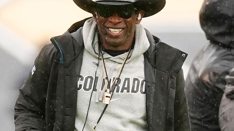 Colorado head coach Deion Sanders smiles during the first half...