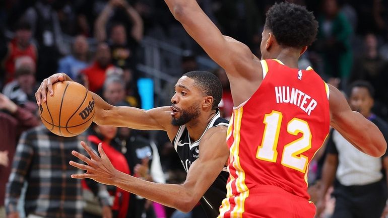 Mikal Bridges (1) of the Brooklyn Nets drives against De'Andre...