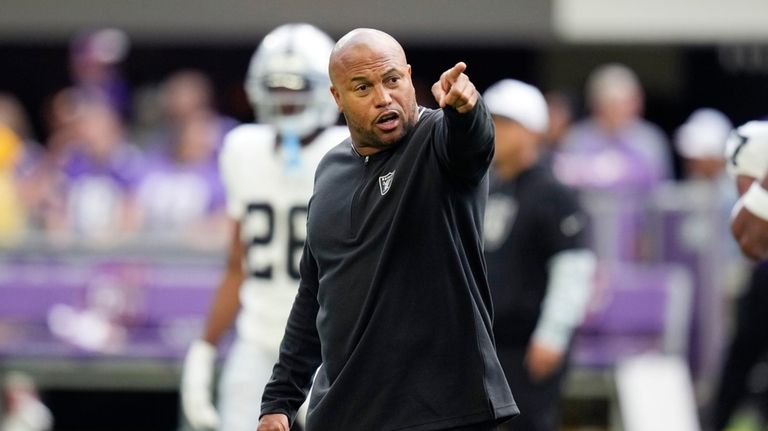 Las Vegas Raiders head coach Antonio Pierce talks to his...