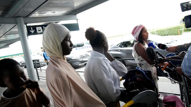 People evacuated from Niger speak to medias at the Roissy...