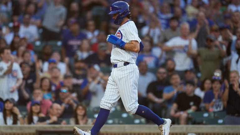 Chicago Cubs' Dansby Swanson scores on a passed ball by...