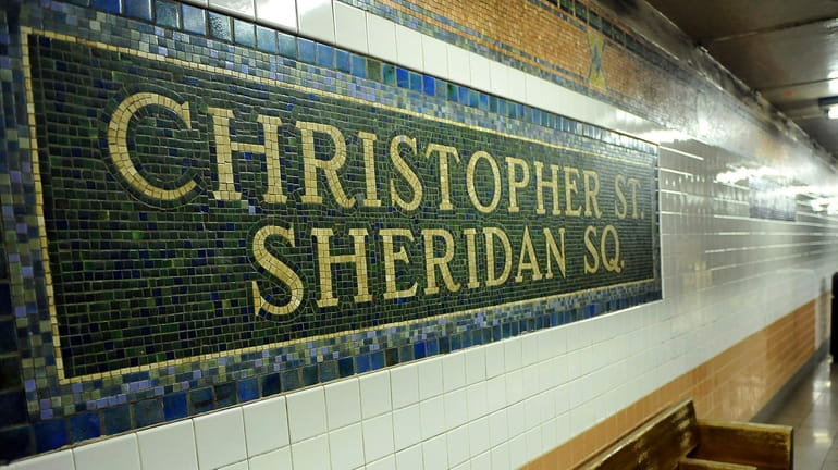 A woman awaits a subway train at the Christopher Street-Sheridan...