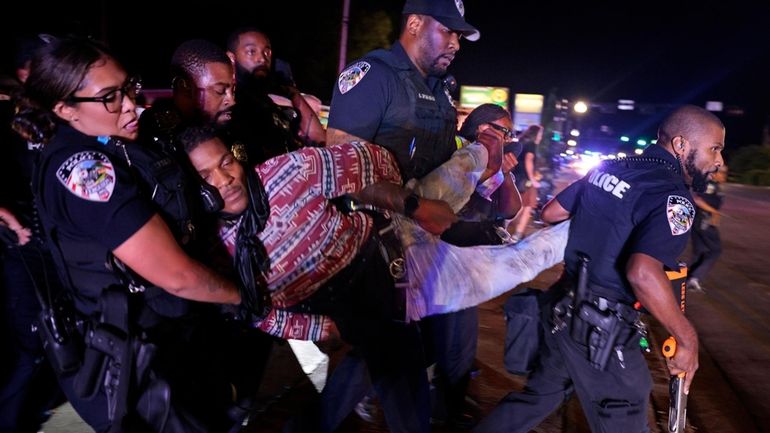 Ferguson police arrest Elijah Gant outside the Ferguson, Mo., police...