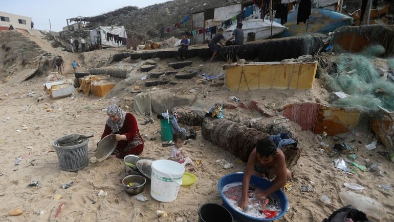 Palestinians resort to the sea water to bathe and clean...