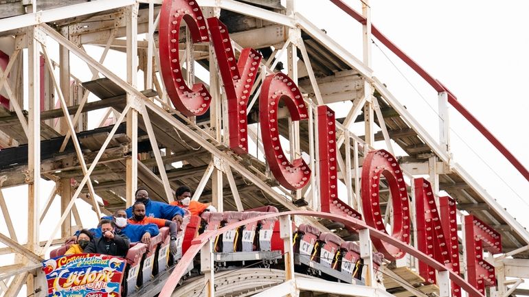 People ride the Coney Island Cyclone roller coaster, April 9,...