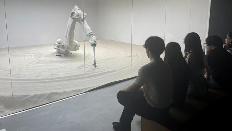 A robot draws pictures in sand at Mercer Labs in...
