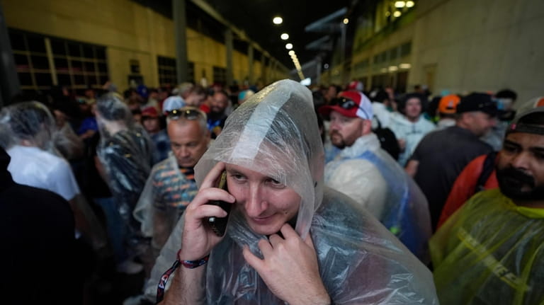 A race fan makes a phone call while trying to...