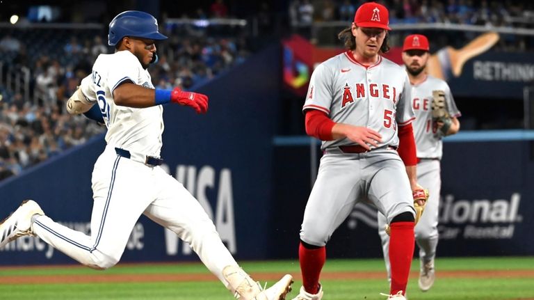 Anaheim Angels relief pitcher Michael Baumann steps on first base...