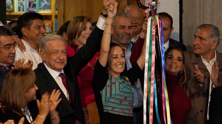 Mexican President Andres Manuel Lopez Obrador raises the hand of...