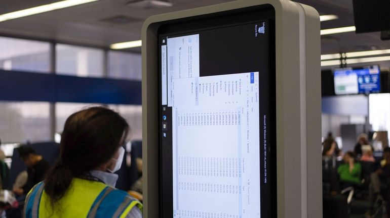 A technician works on an information display near United Airlines...