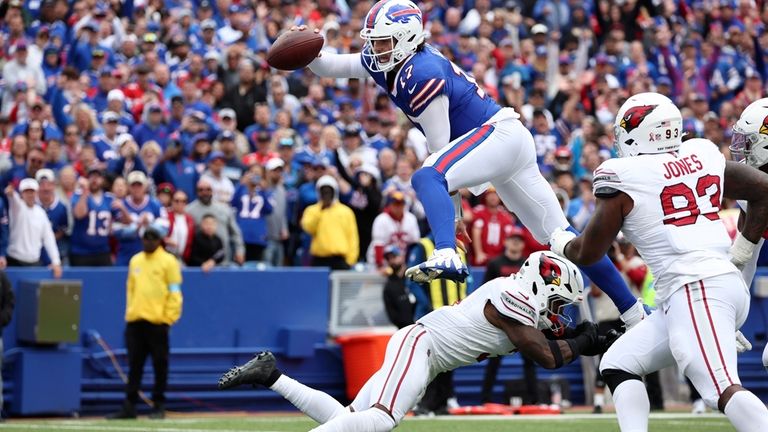 Buffalo Bills quarterback Josh Allen (17) leaps over Arizona Cardinals...