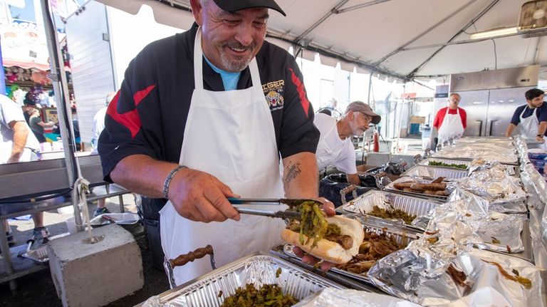 Kevin Monahan makes sausage and pepper sandwiches at the Feast...