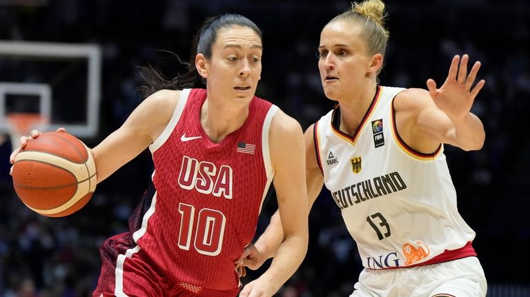 United States' Breanna Stewart, left, drives around Germany's Leonie Fiebich...