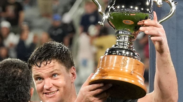 New Zealand captain Scott Barrett holds the trophy after New...