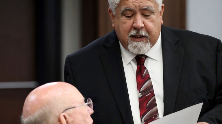 Plaintiff attorney Alton Todd, seated, talks with Roberto Torres, the...